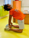 yoga en aula infantil niño en la asana del camello o la letra D