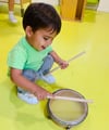 Niño feliz jugando con instrumentos y haciendo música en aula infantil