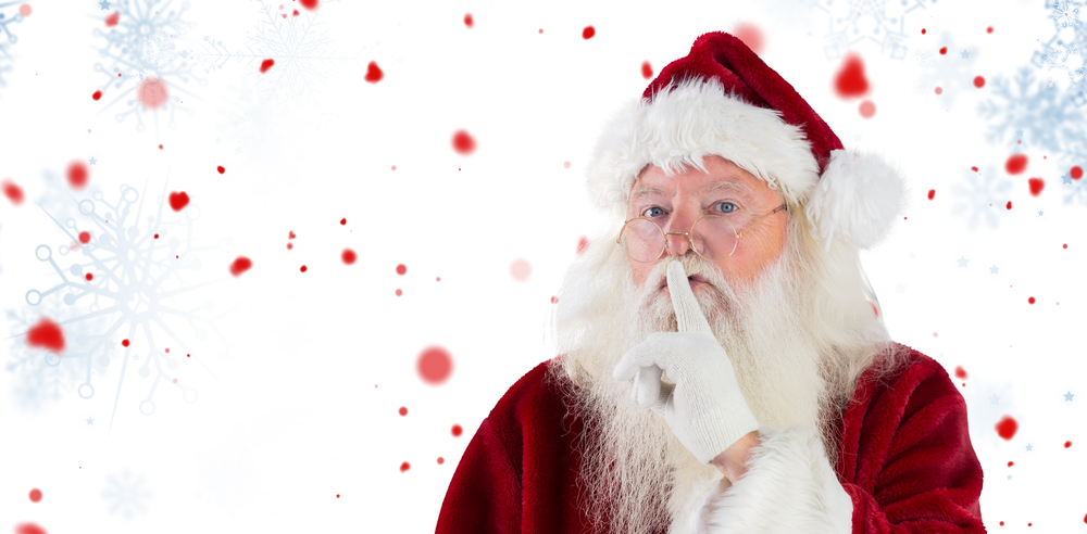 Santa asking for quiet to camera against snowflake pattern Santa asking for quiet to camera against snowflake pattern